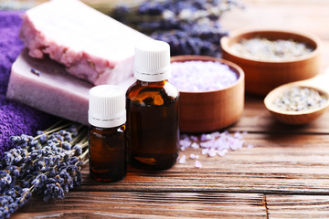 Lavender oil with soap and flowers on brown wooden table