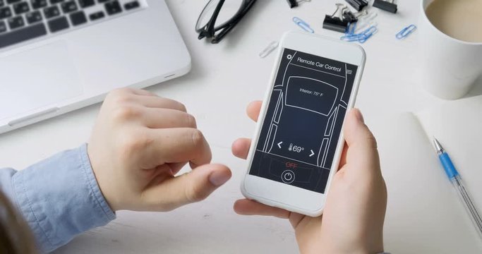 Man remotely changes temperature in his car Car remote control using smartphone application fictional interface.