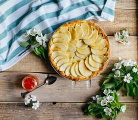 Apple pie with a blossom branch on table