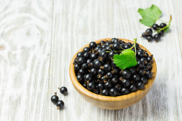 Fresh berries in a bowl on wooden rustic garden table.  Selective focus, space for text.