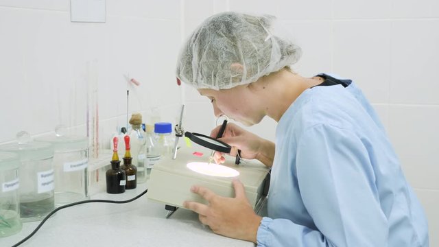 A woman in the laboratory is engaged in research, counting using special equipment