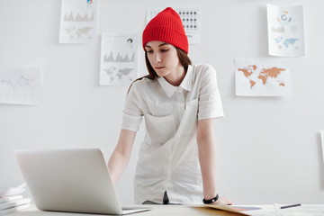 Young woman using laptop while working at the desk