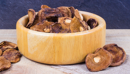 Dried forest mushrooms on a wooden table.