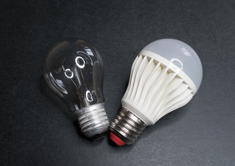 Led lamp and incandescent lamp on a dark background.