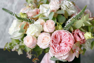 Spring bouquet of mixed flowers on vintage gray wall background behind