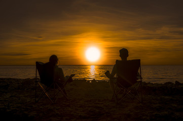 Happy couple enjoy luxury sunset on the beach during summer vacations