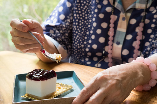 Elder Senoir Eating Blueberry Cheese Cake At Cafe. Asian Elderly Woman Sitting And Tasting Dessert At Restaurant.