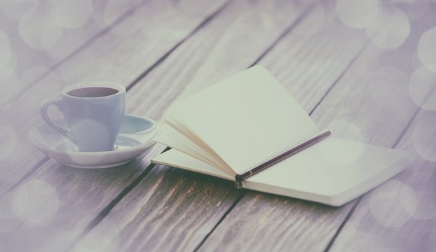 Cup of coffee and notebook with pencil