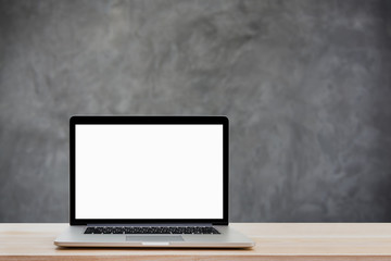 Laptop with blank screen on wood table and gray l background.