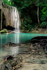 Fototapeta na wymiar Teal and clear water of the Erawan Waterfall in Kanchanaburi, Thailand. 