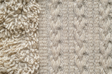 A macro shot of an element of beige color towel. Fleecy part and decorative element with braided pigtails. Texture is similar to the texture of a fleecy knotted-pile carpet.
