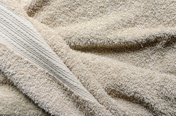 Fototapeta na wymiar Casually lying towel of beige color. Towel folds background