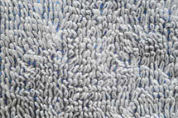 Macro shot of a white towel. Texture is similar to the texture of a fleecy knotted-pile carpet. Chaotically directed white villi on a blue basis
