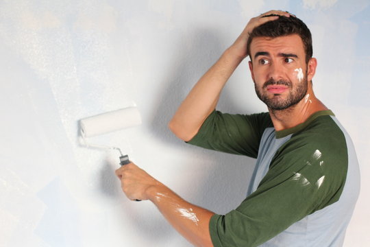 Stressed out male painting his home with space for copy 