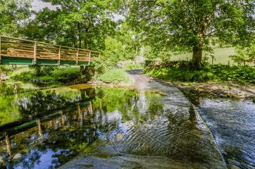 Obraz na płótnie Canvas Footbridge and ford on a stream in a wooded area.