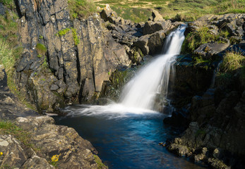Fototapeta na wymiar Waterfall into ocean at Welcome Mouth in Devon