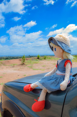 doll on car blue sky background