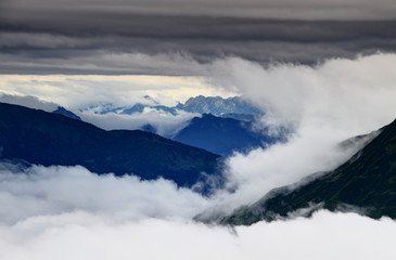 Clouds swirling around and above the ridges of Carnic Alps and Julian Alps in the background, Friuli Venezia Giulia region, Northern Italy, Europe