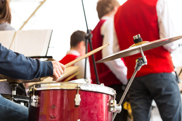 Fototapeta premium drum kit, jazz band music concept - closeup on hand of musician playing with stick on percussion instrument and ride cymbal, orchestra rehearsal before concert performance, selective focus