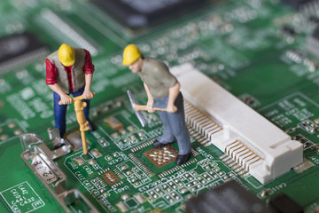 Miniature Workers On Top Of A Circuit Board