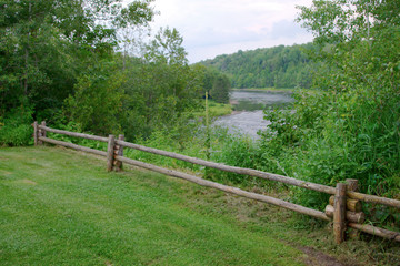 Fototapeta na wymiar green grass river landscape wood fence nature rural scene