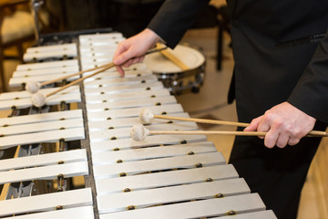 xylophone, percussion instrument concept - closeup on wooden bars with four mallets in human hands,...