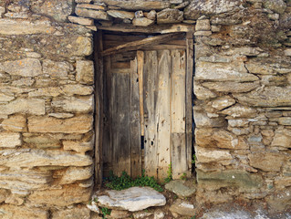 Fototapeta na wymiar Old wooden door on a stone wall