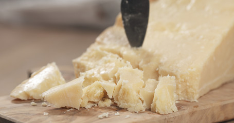 pieces of hard parmesan cheese on olive board