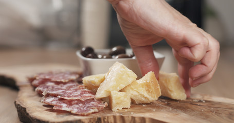 Obraz na płótnie Canvas hands taking italian antipasti appetizers from table