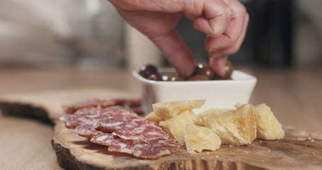 hands taking italian antipasti appetizers from table