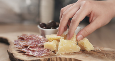 hands taking italian antipasti appetizers from table