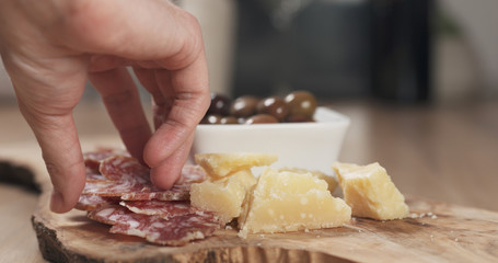 hands taking italian antipasti appetizers from table
