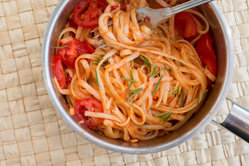 Spaghetti in Topf, mit frischen Tomaten und Rosmarin