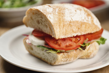 ciabatta sandwich with speck, mozzarella and vegetables