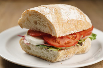 ciabatta sandwich with speck, mozzarella and vegetables