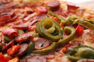 Hot pizza slice with melting cheese on a rustic wooden table. Italien food concept