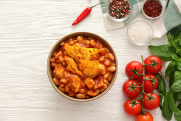 Bowl with delicious turkey chili on wooden background