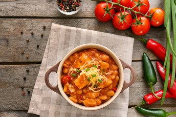 Casserole with delicious chili turkey on wooden background
