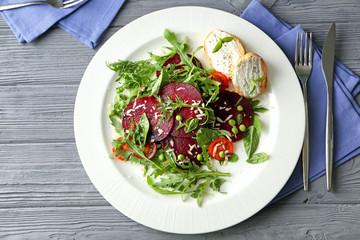 Plate with useful beet salad on wooden background