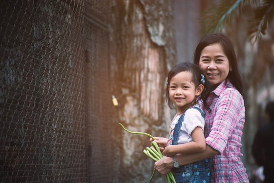 Mother and daughter are feeding monkeys.