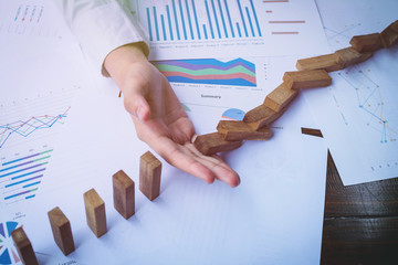 A hand stopping the line of domino effect from falling. Concept image for plan solution, Top view