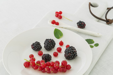 Red currant and blueberries on a white marble cutting board