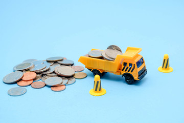 Fototapeta premium save money for investment concept truck toy and Coins on blue background
