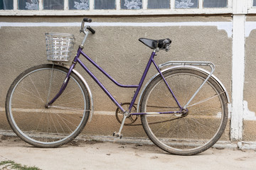 Fototapeta na wymiar Bicycle with a basket in the courtyard of a rural house