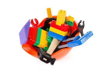 Naklejka premium Concept builder or architect occupation, protective helmet and toy instruments on white