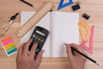 Math school supplies on wooden table in math class. School concept advertisment with math equipment object on school table. Math back ground concept with boy holding pencil.