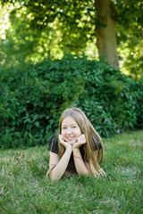 Obraz premium pretty brunette young woman lying on the grass, resting in the park on the weekend