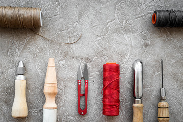 Fototapeta na wymiar Leather craft tools on grey stone background top view copyspace