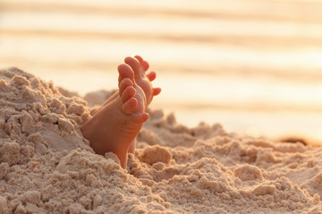 Closeup child feet on white sand beach.