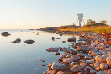 Nautical navigation mark / seamark and islets in the archipelago in the warm light during the...